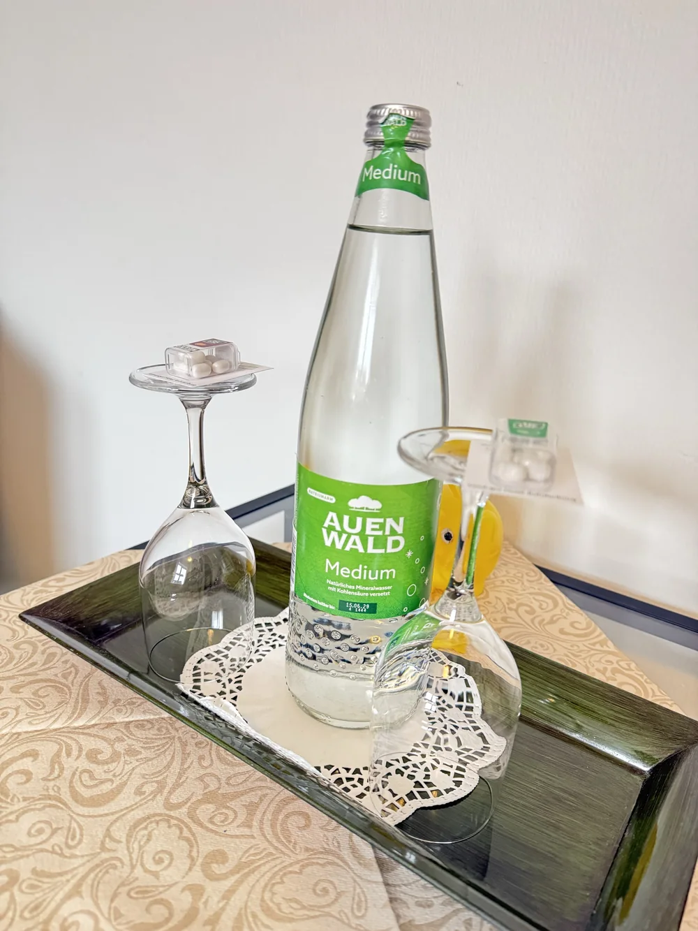 Willkommensgruß mit Mineralwasser und Gläsern auf dem Hotelzimmer